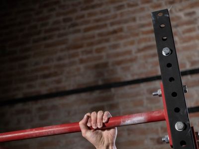 Man hands gripping a metal bar before an exercise